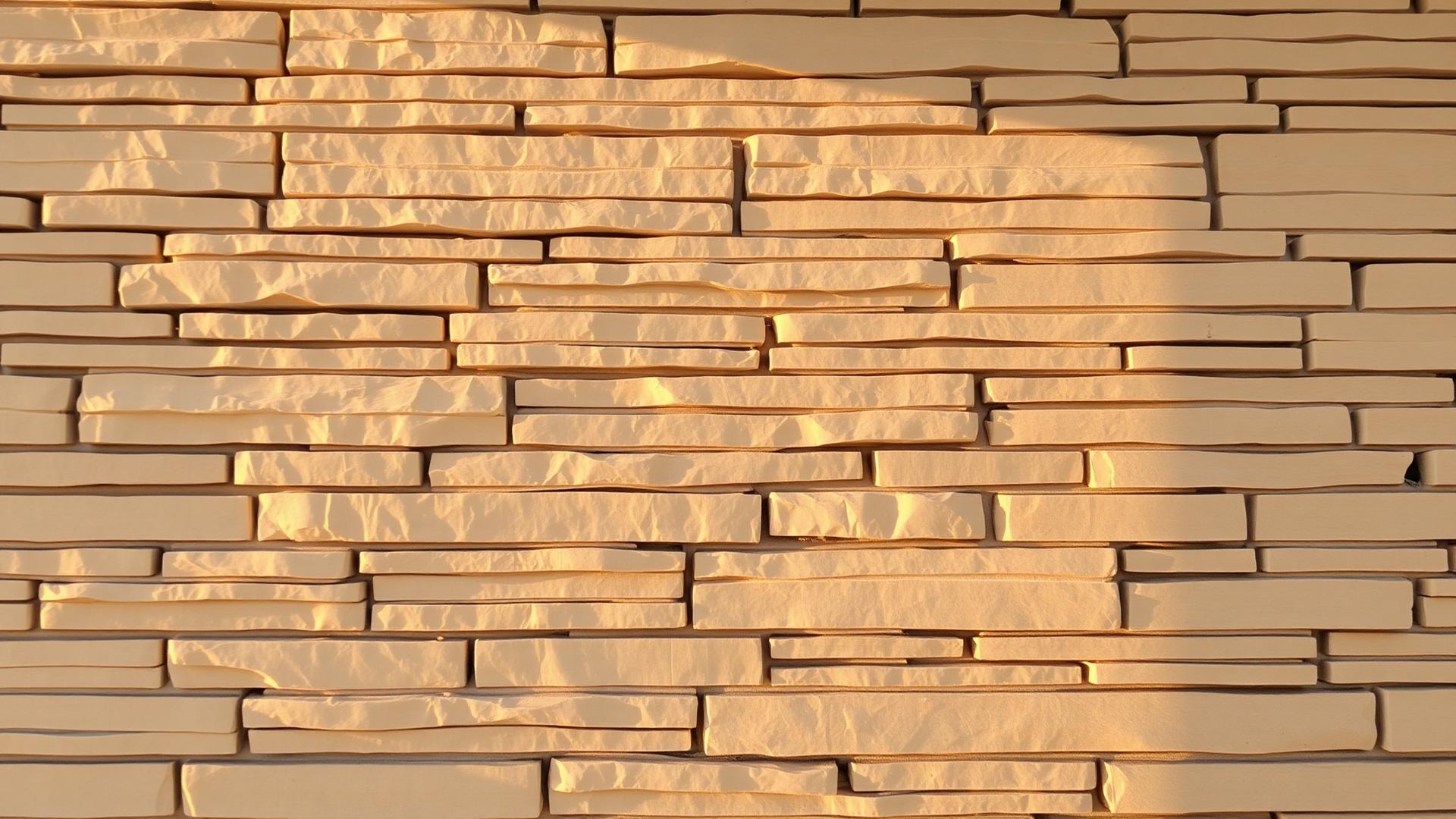 Sunlit hand-laid stone veneer wall with tight mortar joints